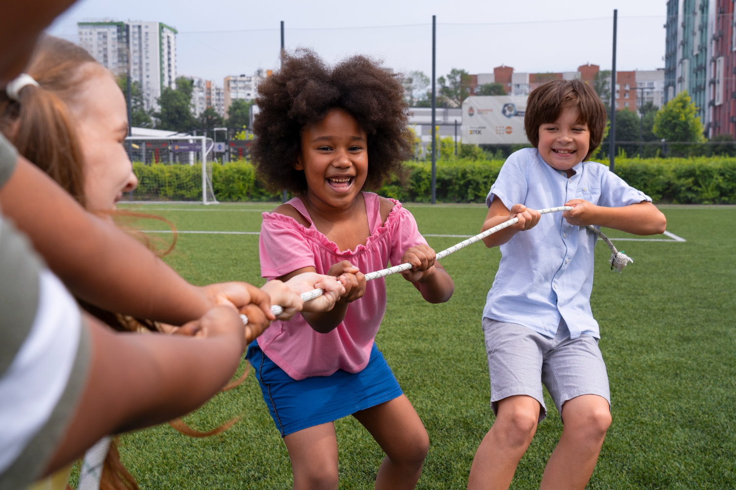Children playing tug of war on a sports field